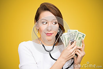 Woman with stethoscope listening to dollar bills making analysis of moneyâ€ investment Stock Photo